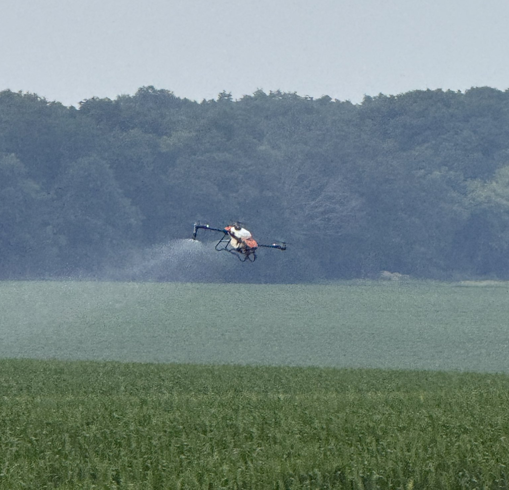 drone flying over field spraying